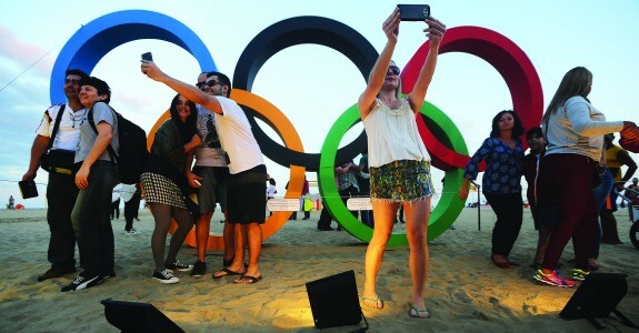 RIO DE JANEIRO, BRAZIL - JULY 23: People take photos in front of a set of Olympic rings, created from recycled material, on Copacabana beach, one of the Olympic venues, on July 23, 2016 in Rio de Janeiro, Brazil. The Rio 2016 Olympic Games commence on August 5. (Photo by Mario Tama/Getty Images)