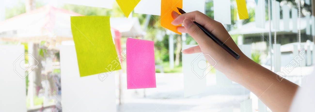 business people post it notes in glass wall at meeting room