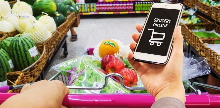 Smart phone with grocery shopping online on screen over blur supermarket background, retail business and technology concept